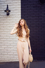 a  beautiful teenage girl in a peach fuzz suit with a waistcoat, in the old money style  walks...