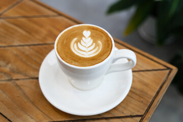 A cup of hot latte coffee on the table for breakfast
