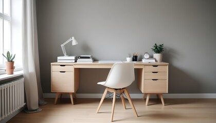 Interior design of modern scandinavian home office with a wooden drawer writing desk and a white chair against a grey wall