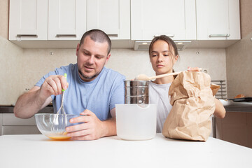 Teenager girl and father preparing baking together, parent-child bonding time, mixing ingredients and enjoying baking.