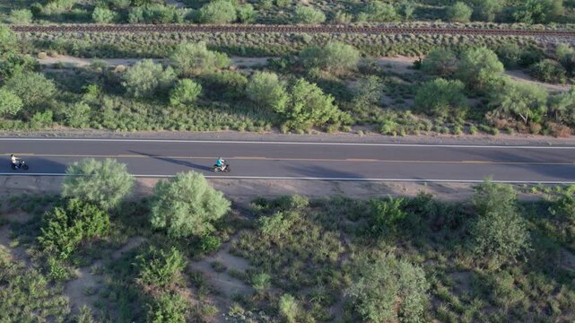 Aerial of seniors riding e-bikes on a country road