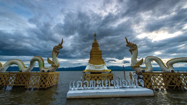 Time lapse of golden pagoda and Twin king of Naga statue at Kwan Phayao Lake at sunset, The most famous landmark at Phayao the north of Thailand 