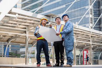 Fototapeta premium Architect boss and engineer worker collaborate are good team, working together at construction site .employer guy explain project or blueprint plan. Blue collar workers working, reading on blueprint.
