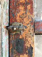 Old door lock latch. There is a rusty lock in the old door.