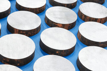 Metal round disks parts cut from metal cylinder lie in a row, industrial background concept