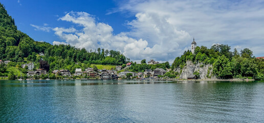 Obraz premium Serene Traunkirchen Lake View: Town Nestled Between Lush Hills and Rocky Church Steeple