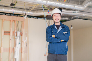 工事現場で腕を組む男性の職人