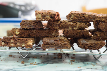 Chocolate brownies with nuts cooling on a wire rack on marble countertop.