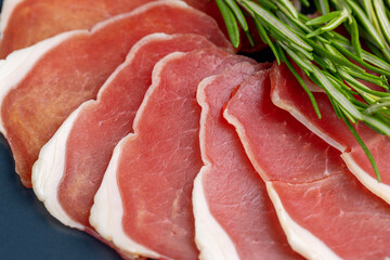 sliced ham with bacon on a board