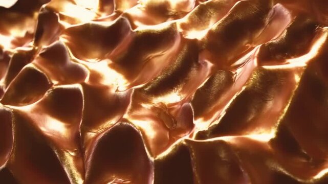 A detailed close-up of a metallic copper surface showcasing intricate, interlocking patterns. The texture appears almost scaly, providing a reflective and shiny finish. The image captures the rich