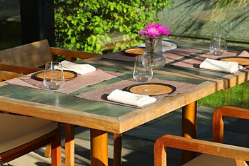 Served tables in a restaurant on an open veranda