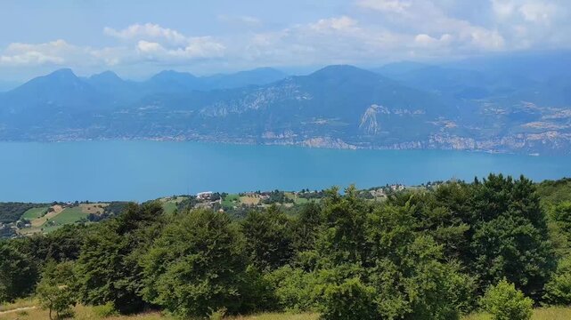 Stunning view of the blue colored Lake Garda and surrounding mountains from a cable car near the town of Prada, Italy.