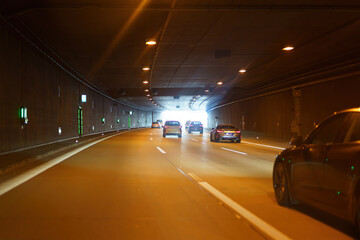 Tunnel on a road with cars and night lighting.