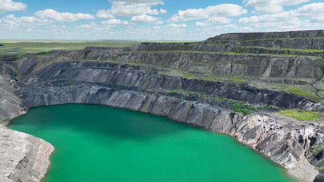 The terraced slopes of abandoned flooded coal mine in the steppe.