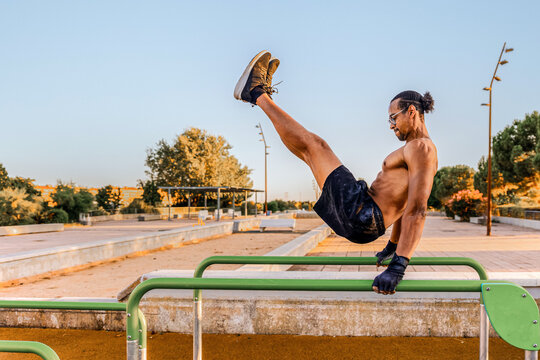 Man doing calisthenics on parallel bars outdoors