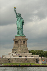 Obraz premium New York, NY, USA - August 4, 2023: Statue of Liberty front portrait, from the bay plus under gray cloudscape