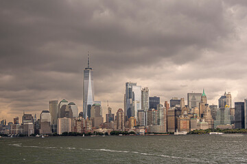 Fototapeta premium New York, NY, USA - August 4, 2023: Lower Manhattan skyline under gray intimidating cloudscape, seen from the SW