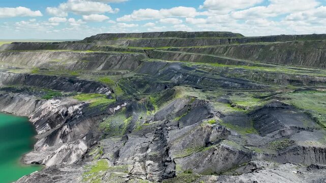 An abandoned flooded coal quarry carved with cracks.
