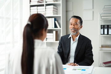Senior manager smiling during a job interview with a female applicant in the office