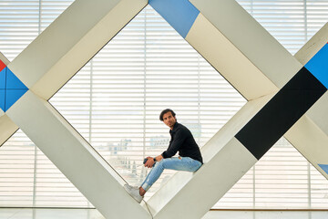 Man Sitting on Modern Indoor Structure