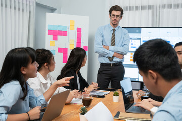 Project manager planning schedules for business task at meeting room, Gantt chart software show on TV screen. Multi ethnic diversity business people and modern business project management. Habiliment