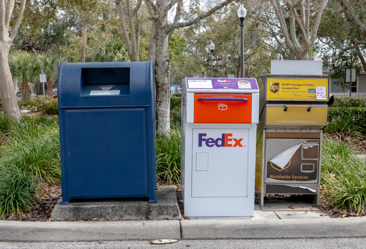 USPS, Fedex and UPS parcel drop boxes in parking lot. Kissimmee, Fl, USA. 2-19-24