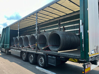 An open semi-trailer truck carrying metal wire. Industrial logistics and transportation of goods