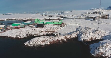 Lonely polar station on Antarctica ocean coast. South Pole science research Vernadsky base aerial view. Global warming, climate change, wild nature exploration. Antarctic travel expedition discovery
