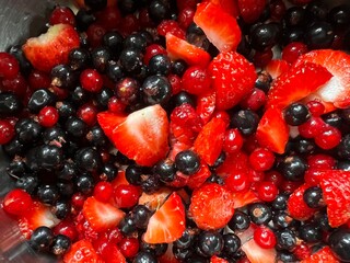 Close up of raspberries, strawberries, red currants, black currants, the ripe juicy and healthy eatingfreshly picked berries from organic country garden allotment fruit trees for vegan salad flat lay 
