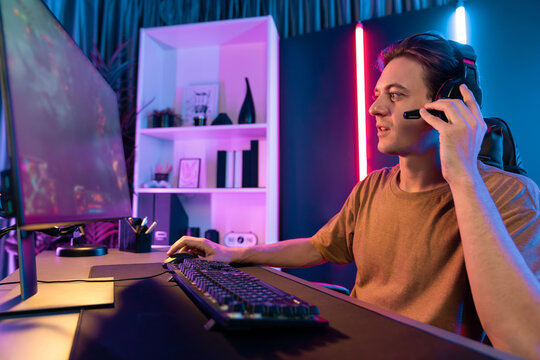 Host channel concentrated smart gaming streamer playing the fighting Moba on computer screen with muptiplayers or single at battle arena . Esport live streaming at neon digital light room. Pecuniary.