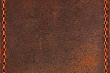Brown leather surface with stitching along the vertical edges and copyspace. The leather has a textured, worn appearance, and the stitching is even and highlights the craftsmanship of the material.