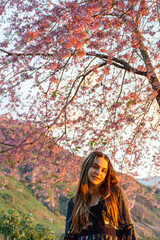 Crian&ccedil;a adolescente feliz balan&ccedil;ando debaixo da arvore no por do sol