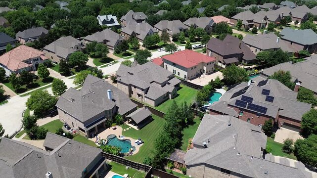 Upscale suburban two-story mansion houses with inground pool, solar roofing, colorful shingle tile roofs in wealthy residential neighborhood Coppell, suburbs Dallas Fort Worth metroplex, flyover