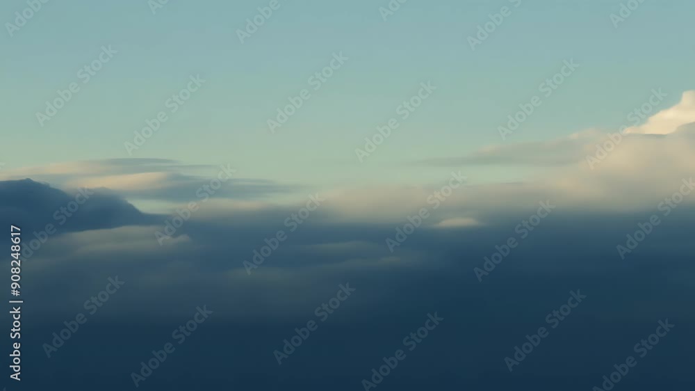 Poster a hazy horizon with billowing clouds creating dramatic shadows that dance across the sky.