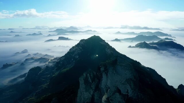 A lone island peak stands tall surrounded by a sea of lowlying clouds giving a sense of isolation and serenity.
