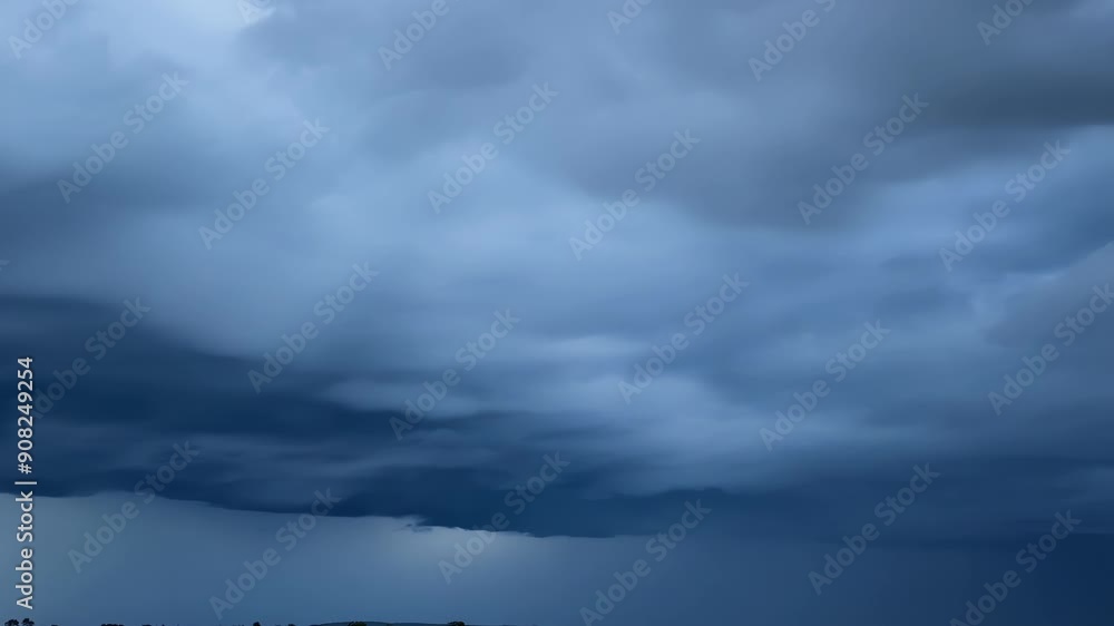 Poster the rolling storm clouds move with alarming speed appearing to devour the blue sky in their path.