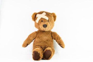 A brown teddy bear with a bandage on its head