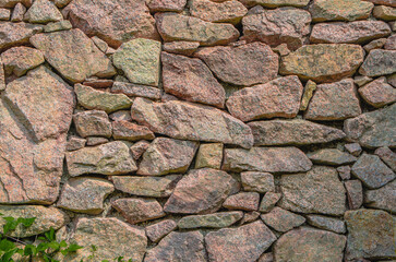 stone wall, texture, Medieval natural stone wall, pink granite, French masonry stone wall, background for photo.,moss, plants on the stone wall
