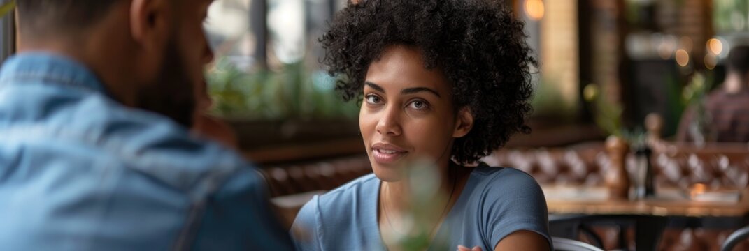 Woman showing skepticism toward her male partner during authentic conversation at a restaurant - Powered by Adobe