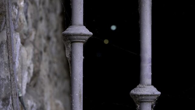 Creepy tunnel with gate and spiderwebs and zombie hand coming from the darkness in halloween