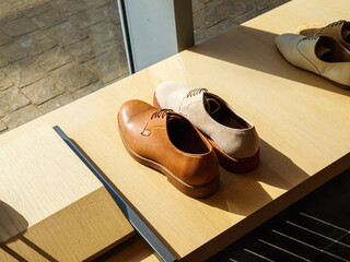 Presentation of Luxury male shoes displayed next to female shoes in a showcase window, highlighting...
