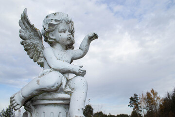 Sad guardian angel sculpture with open long wings across