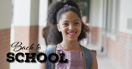 Image of back to school text over happy biracial schoolgirl at school