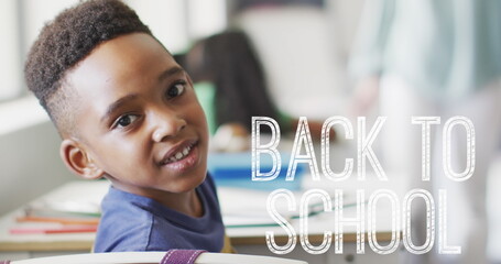 Image of back to school text over happy african american schoolboy at school
