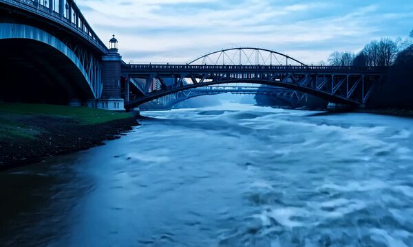 Twin Bridges at Twilight: A rushing river flows beneath the imposing silhouettes of two bridges, captured in the ethereal glow of twilight, evoking a sense of timeless strength and the inexorable pass