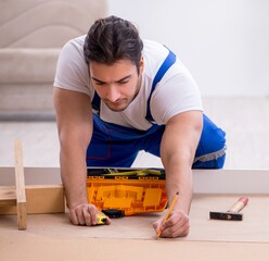 Young male contractor installing furniture at home