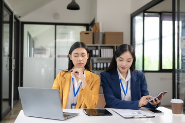 Two Asian women are checking their income by working in online sales. with laptops because sales are in line with desired targets
success