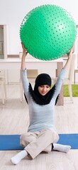 Young woman in hijab doing exercises at home