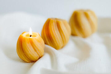 Handmade candles from natural beeswax in the shape of flowers, bears on a white background. Hobby. Handmade present. Gift. Artistic photo of beekeeping products in white room. Mockup. 