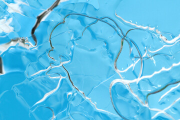 Macro shot of thin layer of frozen ice surface on blue background
